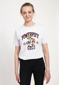 Bílý bavlněný tričko s grafickým potiskem tří animovaných postaviček z "Powerpuff Girls", s růžovým písmem a hvězdnými akcenty.