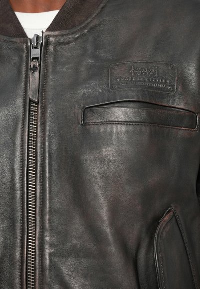 MustHave nahkaga bomber jakk, millel on ees lukk, soonik kaelus ja plaastritasku. Omab siledat tekstuuri ja õrnate kulumismärkidega detaile.