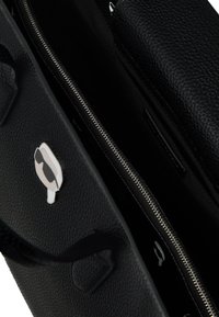 Zwarte gestructureerde leren tas met een ritssluiting, een interieurcompartiment en een externe speldaccent. Minimalistisch ontwerp en compacte vorm.