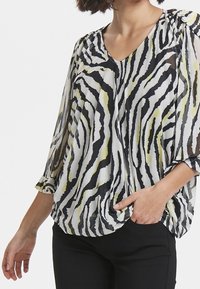 Černobílé pruhované blůza s žlutými akcenty, lehký materiál, výstřih do V, tříčtvrteční rukávy a volný střih.