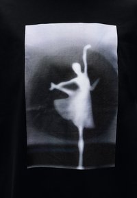 Μαύρο μπλουζάκι με εκτυπωμένο γκριζοασπρο γραφικό χορευτή σε τουτού, με εφέ απαλής εστίασης και βαθιές μεταβάσεις φόντου.