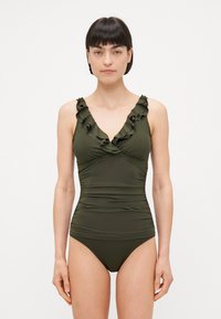 Olīvu zaļš viengabala peldkostīms ar rumbu V-veida kakla izgriezumu, drapēts audums jostas vietā un eleganta, gluda tekstūra.