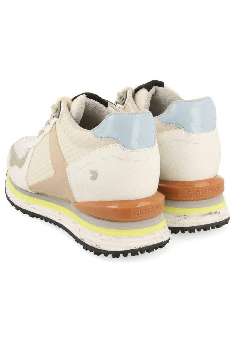 Zapatillas blancas con acentos en beige y azul claro. Material texturizado, cuello acolchado y una suela multicolor con capas naranjas y amarillas.