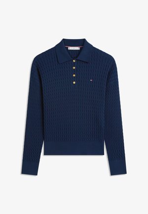 Granatowa, dzianinowa koszulka polo z długim rękawem, złotymi guzikami i małym czerwono-biało-niebieskim logo na piersi.