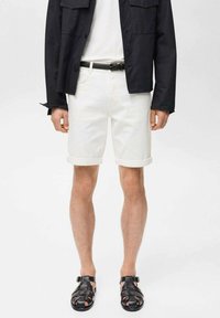 Weiße Jeansshorts mit umgeschlagenen Säumen, kombiniert mit einer schwarzen Hemdbluse und schwarzen geflochtenen Sandalen. Minimalistisches Design, glatte Textur.