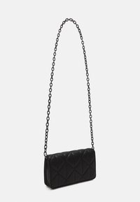 Sac à main matelassé noir de forme rectangulaire, doté d'une longue chaîne comme bandoulière et d'une texture lisse, conçu avec des motifs en forme de diamants.