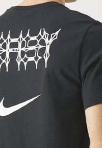 Black t-shirt featuring a distorted white graphic with "EASY" text on the back and a white Nike logo on the front. Cotton material.