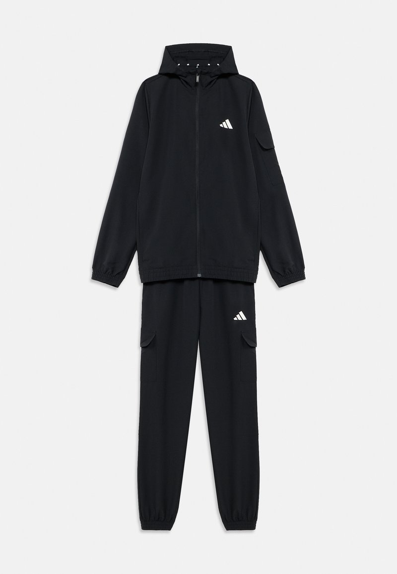 Μαύρη φόρμα που αποτελείται από μπουφάν με φερμουάρ και κουκούλα, καθώς και αντίστοιχο παντελόνι με τσέπες cargo. Κατασκευασμένη από λείο, ελαφρύ ύφασμα.