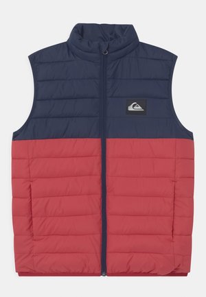 Veste matelassée sans manches avec partie supérieure bleu marine et partie inférieure rouge, fermeture éclair frontale, col montant et petit patch logo sur la poitrine.