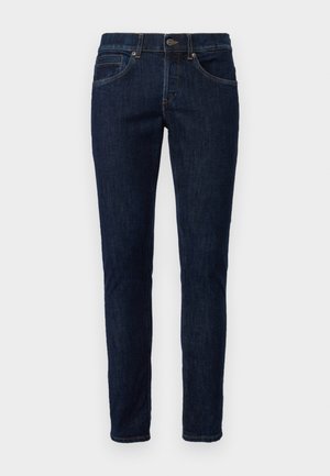 Jeans in denim blu scuro con un taglio slim. Presentano cinque tasche, una chiusura a zip e passanti per cintura. Cuciture di un colore contrastante.