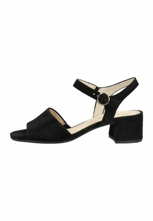 Czarna zamszowa sandałka z odkrytymi palcami, paskiem wokół kostki z okrągłą srebrną klamrą, niskim obcasem typu klocek i beżową wyściółką wewnętrzną.