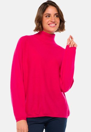 Pull à col roulé oversize rose avec un ajustement snug au niveau du cou, des manches longues et une texture douce. Style décontracté, parfait pour les superpositions.