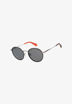 Runde schwarze Sonnenbrille mit dünnen silbernen Rahmen und orangefarbenen Bügelenden, vor weißem Hintergrund gezeigt.