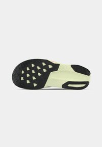 Black and light green athletic shoe sole, featuring a textured pattern with diamond shapes and a smooth section for grip.