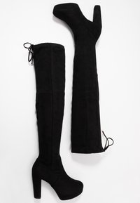 Stivali over-the-knee in suede nero con tacco spesso. Presentano un gambale alto, un laccio regolabile in cima e una texture liscia.