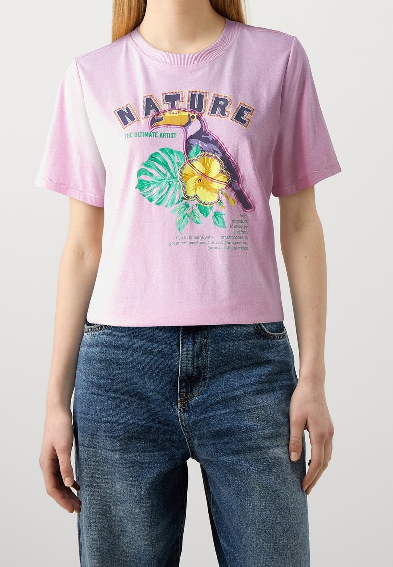 Short-sleeve, pastel pink T-shirt made of cotton, featuring a colorful toucan, floral graphics, and the word "NATURE" in bold letters.