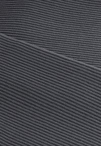 Tissu côtelé gris foncé avec de fines rainures horizontales, plié en diagonale au centre, montrant les détails de la texture et du motif.