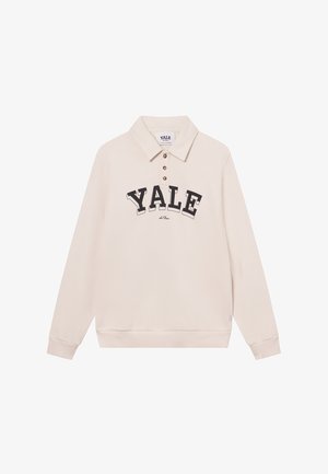 Light beige long-sleeve polo with a collar, featuring a large black "YALE" print and three brown buttons. Soft cotton blend fabric.