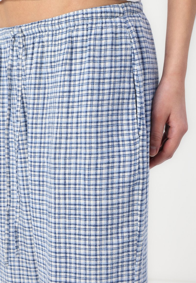 Lekkie piżamy w kratkę w kolorze niebieskim i białym, z luźnym krojem, elastycznym pasem i bocznymi kieszeniami. Miękka tekstura i swobodny design.