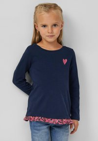 Marineblaue Langarm-T-Shirt mit pinkem Herzdetail und Rüschensaum im Blumenmuster. Aus Baumwolle, lockere Passform, runder Ausschnitt.