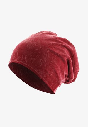 Panta beret samet merah dengan desain longgar. Memiliki tekstur lembut, permukaan halus, dan pola kerut halus di seluruhnya.