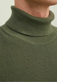 Khaki-vihreä polo kauluksellinen villapaita, joka on valmistettu teksturoidusta neuleesta ja joka sisältää ribbipipon ja vartalon lämpöä ja mukavuutta varten.