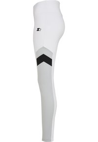 Leggings blancs au design ajusté, avec un panneau gris et un motif en chevron noir sur le côté, ainsi qu'un logo sur la hanche.