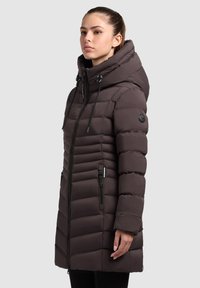 Brown puffer coat with a hood, featuring horizontal quilted sections, zippered front, and adjustable drawstrings. Smooth texture, casual design.