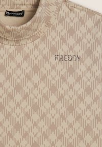 Maglietta beige a maniche lunghe con un motivo geometrico, caratterizzata da un collo a giro e la scritta "FREDDY" in strass sul davanti, realizzata in un tessuto morbido.