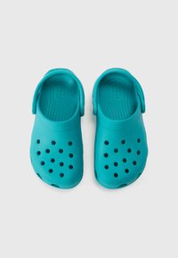 Turkoossed paksupõhjalised kingad, millel on sile, matt viimistlus, mitmed õhutusavad ja tagumised rihmad kindlaks istuvuseks.