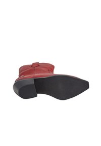 Botín de cuero rojo hasta el tobillo con puntera redondeada, cremallera lateral y suela de goma texturizada con un patrón antideslizante.