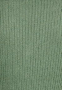 Green ribbed fabric with a textured surface, featuring vertical lines and a soft, subtle sheen. Material appears stretchable and lightweight.
