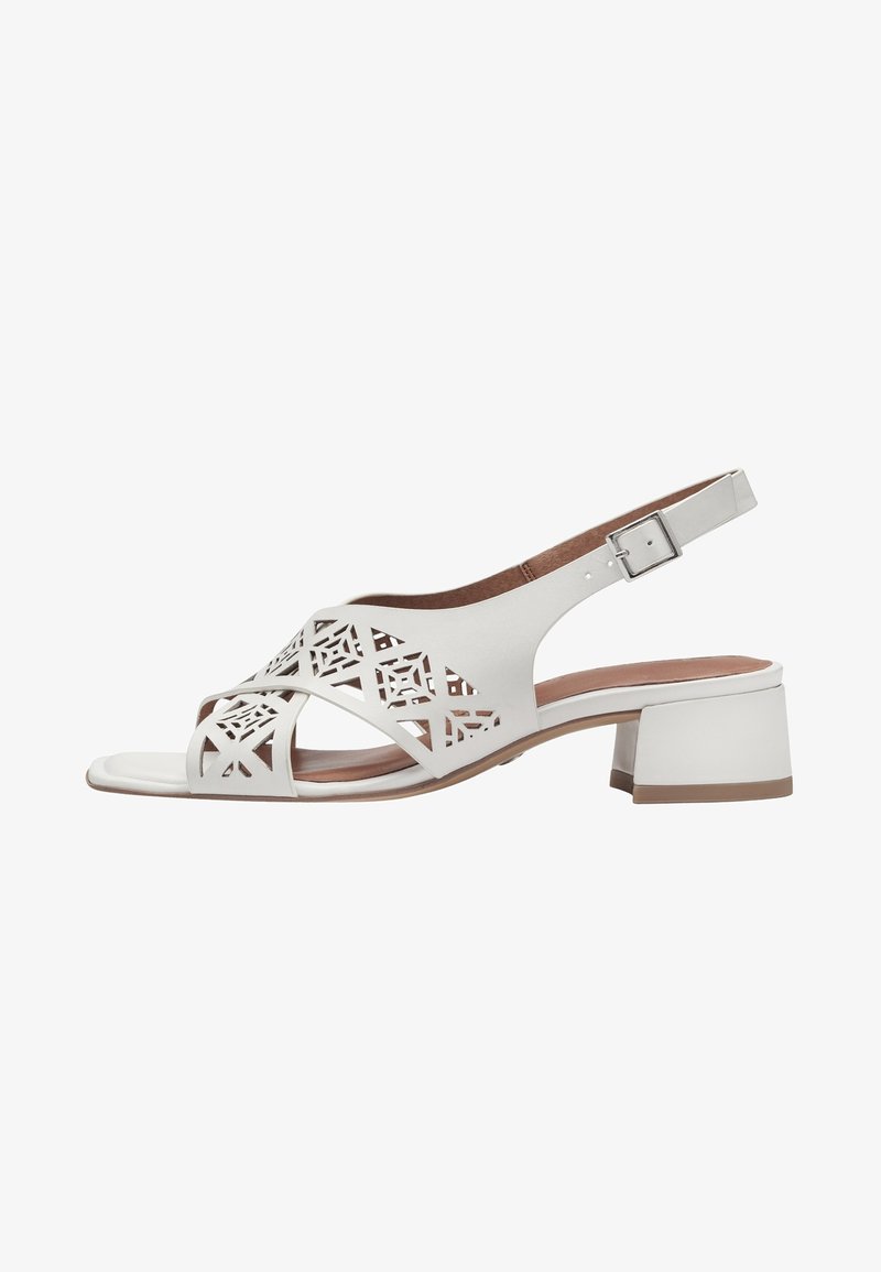 White leather sandal with cut-out geometric design, slingback strap, and low block heel. Smooth texture and brown insole contrast the white.