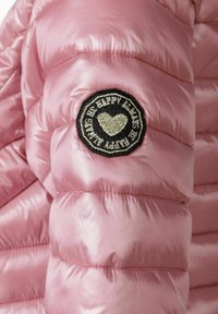 Rosa vadderad jacka med en glänsande yta, prydd med en svart cirkulär patch med broderad text och hjärtdesign på vänster ärm.