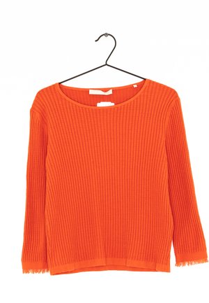 Pull orange côtelé avec un col rond et des manches longues, présentant un ourlet légèrement effiloché et un tissu texturé. Suspendu à un cintre noir.