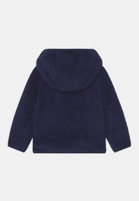 Mörkblå fleecejacka med huva, med en mjuk textur och en avslappnad passform. Inga synliga knäppningar, med en ren baksidedesign.