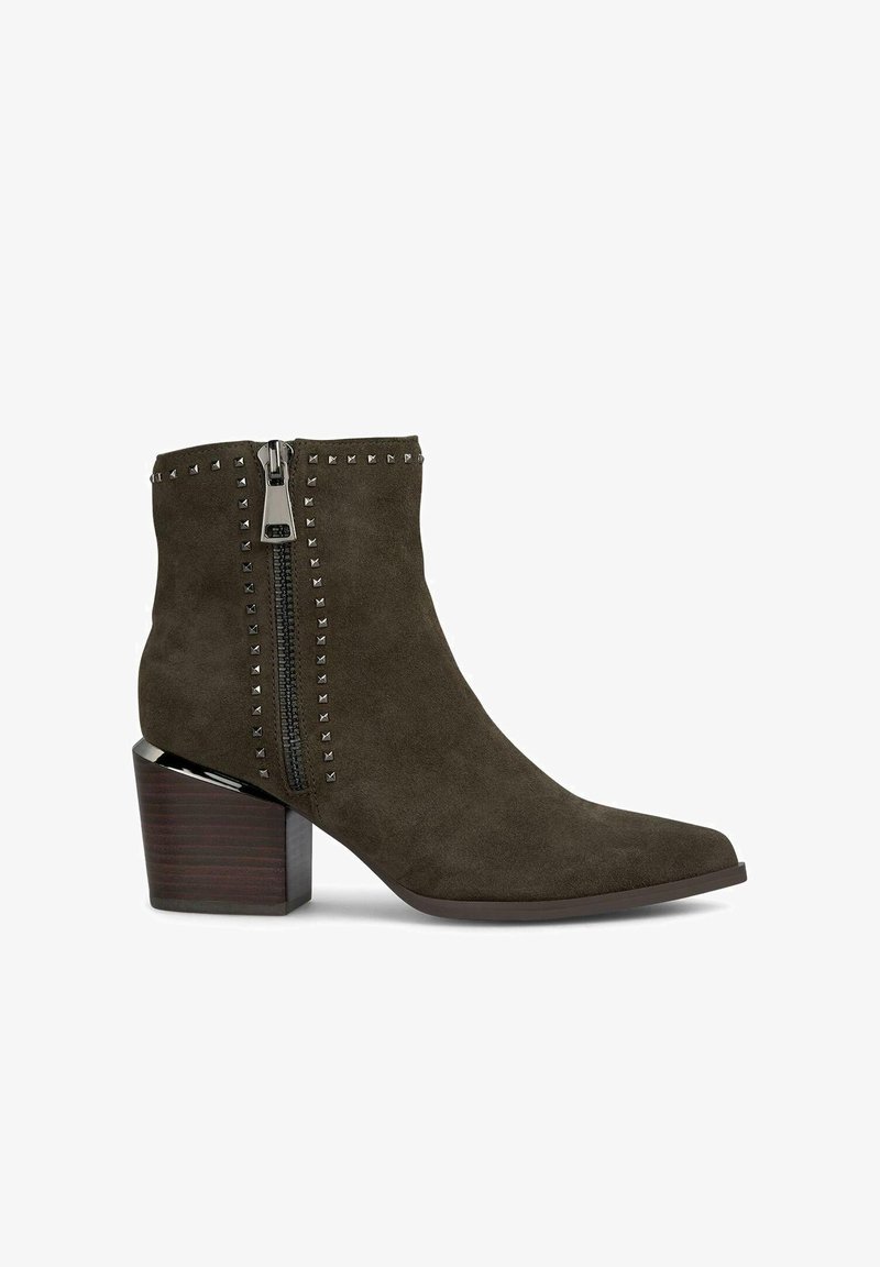 Zielone zamszowe botki za kostkę z ostro zakończonym noskiem, bocznym zamkiem błyskawicznym i metalowymi ćwiekami wzdłuż zamka. Posiadają masywny brązowy obcas.