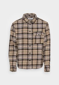 Brun och svart rutigt flanellskjorta med krage, knappfront och en bröstficka. Mjuk struktur, långa ärmar.