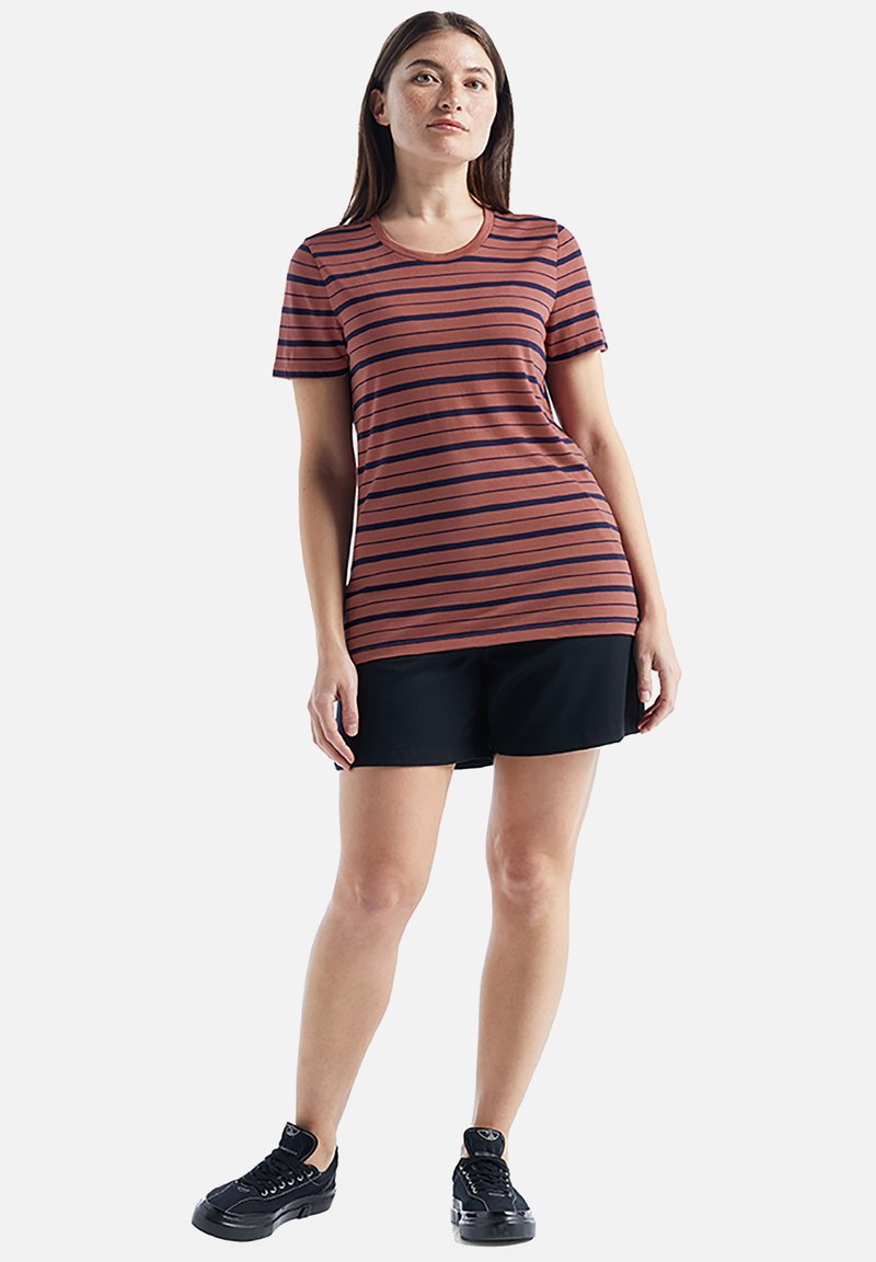 Striped short-sleeve t-shirt in rust and navy, round neckline, paired with black shorts and black athletic shoes. Smooth fabric texture.