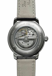 Stainless steel watch back with automatic movement visible; gray leather strap; engraving includes "WR 5 ATM" and "Made in Germany."