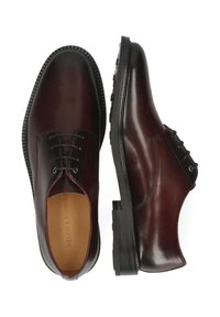 Scarpe di pelle bordeaux scuro con una finitura liscia, punta tonda, sei fori per i lacci e una suola in gomma nera robusta. Accenti di cucitura delicati.