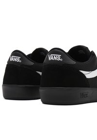 Black Vans sneakers feature a mesh upper with suede accents, white logo detailing, and a solid black rubber sole.