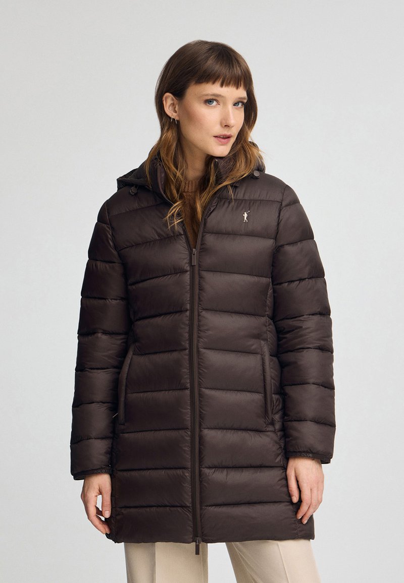 Brun pufferjacka med huva, dragkedja fram och vertikalt kviltat mönster. Har sidofickor och en liten logotyp på bröstet.