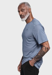 Blaues T-Shirt mit kurzen Ärmeln aus weichem Stoff, mit Rundhalsausschnitt und dezentem Logodetail auf der Brust.