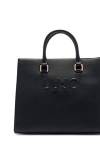 Geantă tote din piele neagră cu două mânere, logo embosat „LIU•JO MILANO” pe față și accesorii metalice aurii. Textură netedă.
