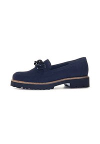 Mocassin en suède bleu marine avec une semelle en caoutchouc noir épaisse, un bord cousu marron et un nœud décoratif en cordon noir sur le dessus.