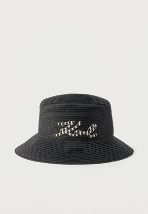 Black woven bucket hat with wide brim and cursive white and black striped "Karl" embroidery on front.