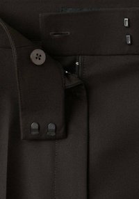 Pantalon marron avec devant plat, fermeture à bouton, accents métalliques et détails cousus. Fabriqué en tissu texturé avec une coupe ajustée.