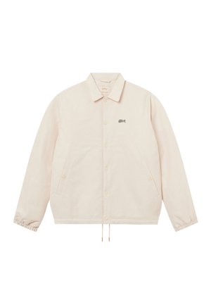 Giacca beige chiaro con bottoni, maniche lunghe, coulisse all'orlo, polsini elastici, due tasche laterali e piccolo logo nero sul petto a sinistra.