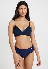 Marineblauw bikini-set met een cross-strap bralette met textuurdetails en bijpassende laag uitgesneden bottoms met een klein logo-embleem.
